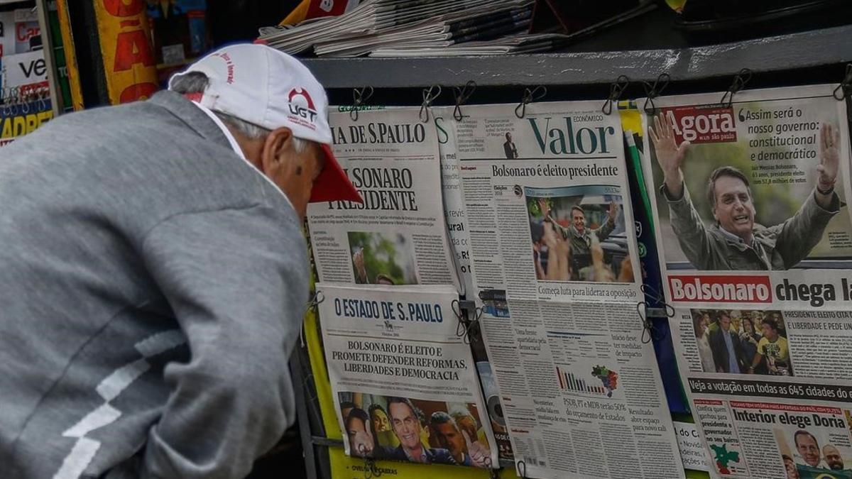 Un hombre lee en la prensa sobre la victoria de Bolsonaro.