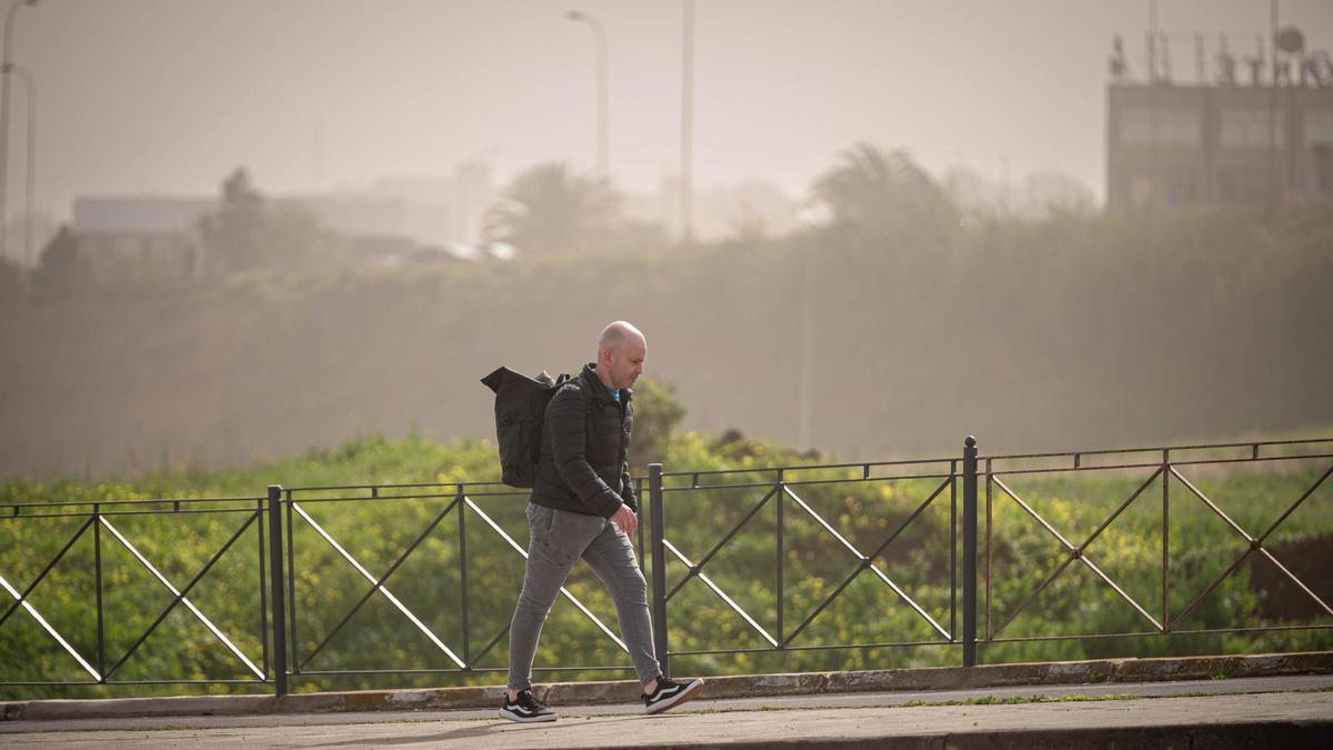 Un hombre camina bajo la espesa calima.