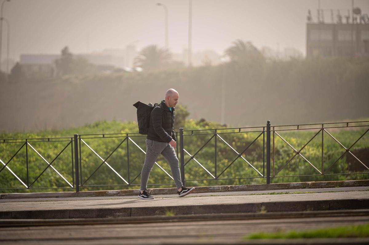 Un hombre camina bajo la espesa calima.