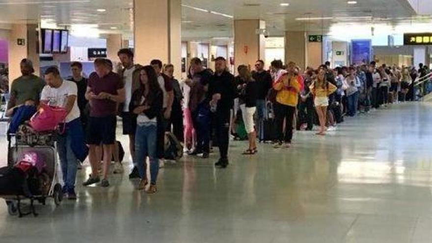 Multitud de personas, en una larga cola para pasar el control en el aeropuerto de Ibiza el pasado domingo.