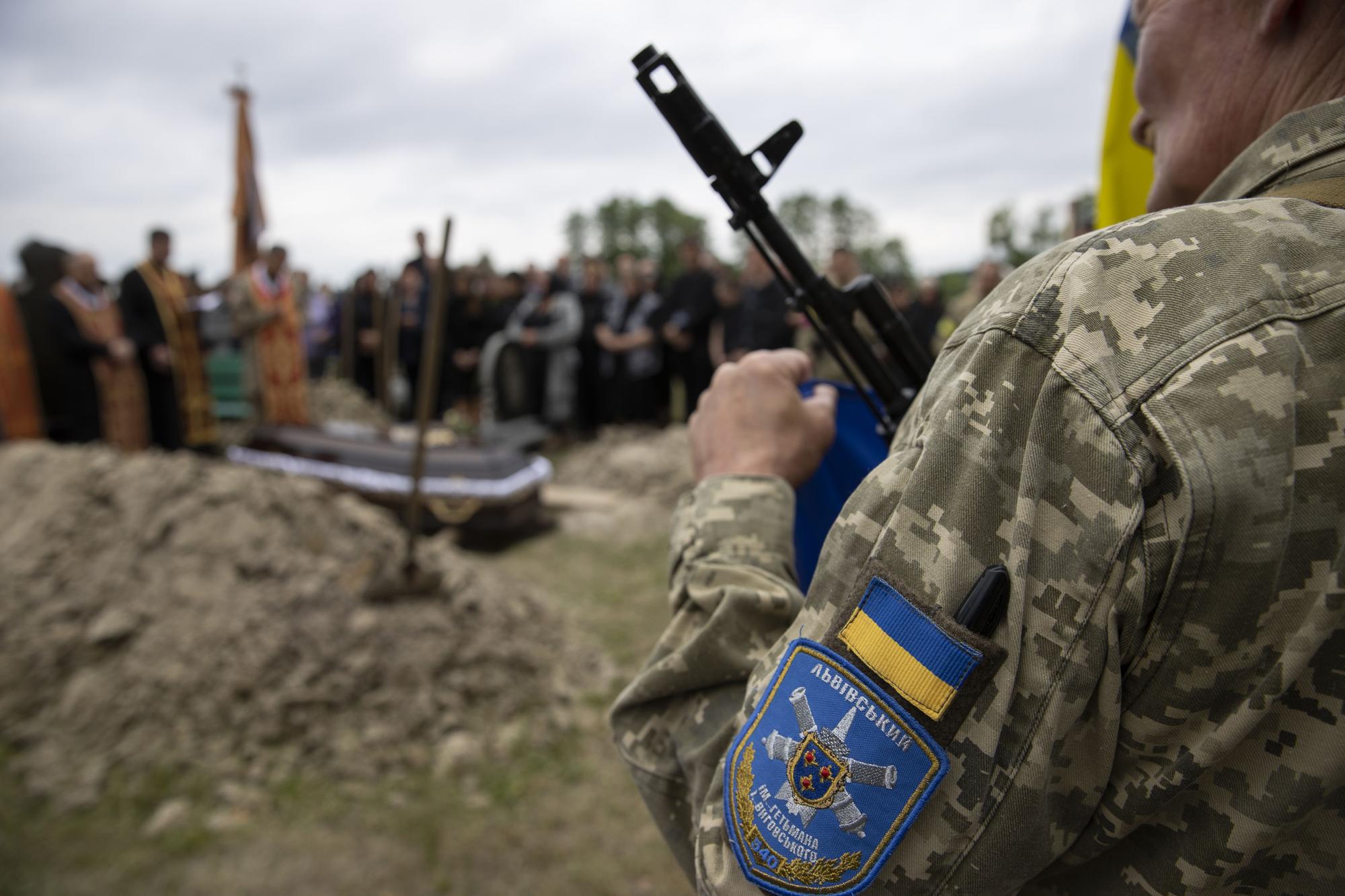 Un soldado custoria un entierro en Severodonestk.