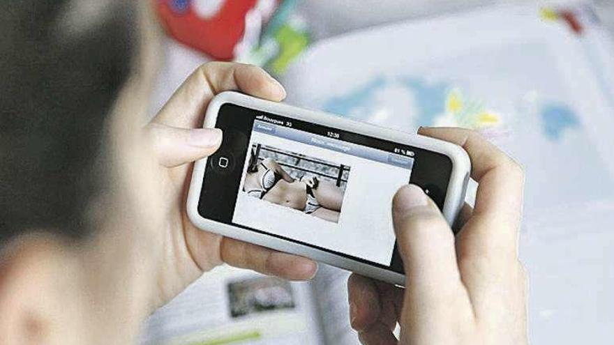 Un joven viendo una imagen de una mujer en ropa interior.