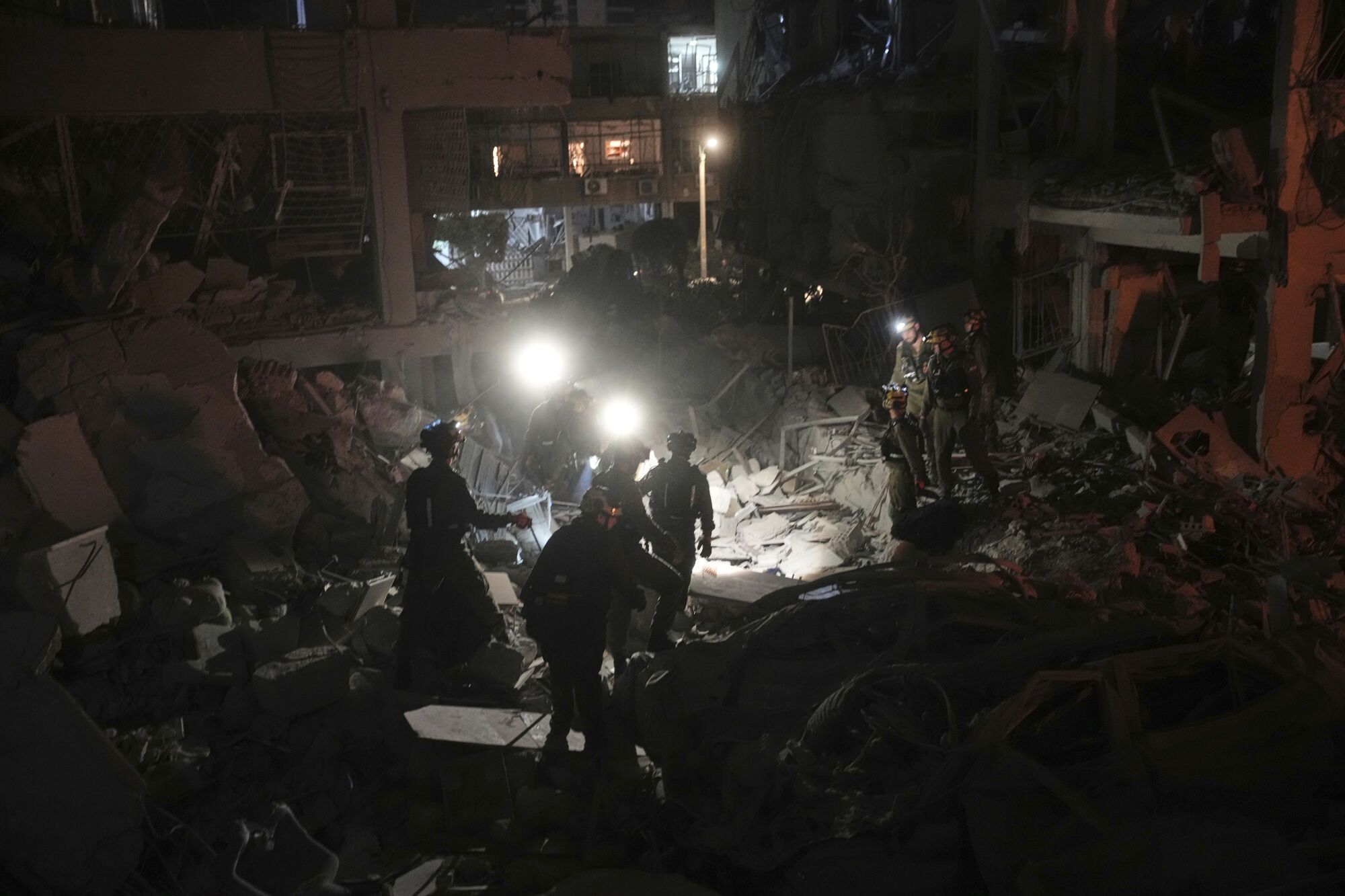 Israeli soldiers search for survivors amid the rubble of residential buildings destroyed by an Iranian missile strike in the central Israeli city of Bat Yam, on Sunday, June 15, 2025. (AP Photo/Ohad Zwigenberg)
