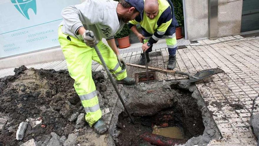 Operarios del Concello, ayer, solventando la avería que causó el vertido de fecales. // Bernabé / Cris M.V.