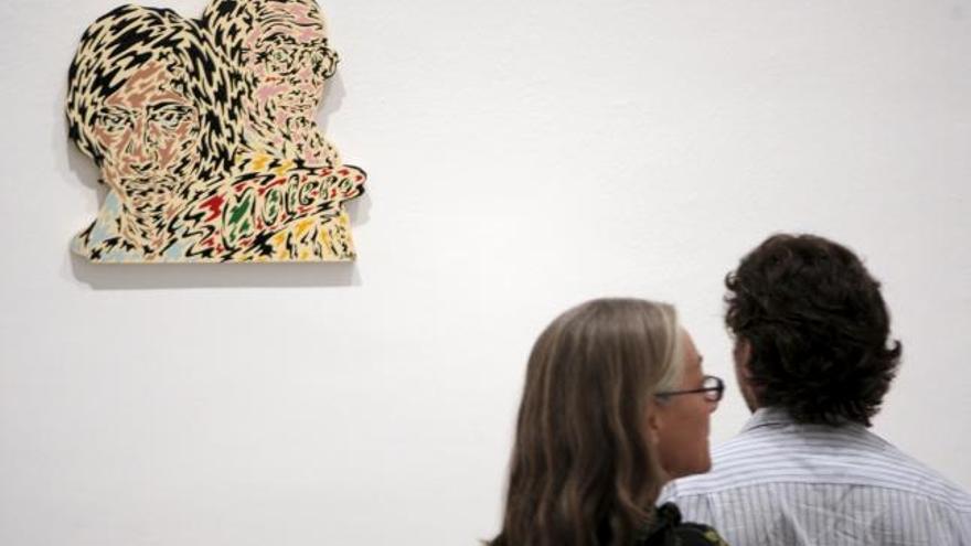 Una pareja observa una de las obras incluidas en la exposición &quot;Los esquizos de Madrid. Figuración madrileña de los 70&quot;, muestra que el Museo Reina Sofía dedica a unos artistas reconocidos como grupo.