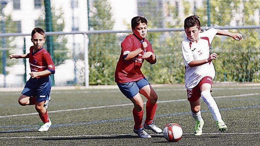 Un jugador del Hogar y otra del Santa Mariña disputan un balón. // José Lores