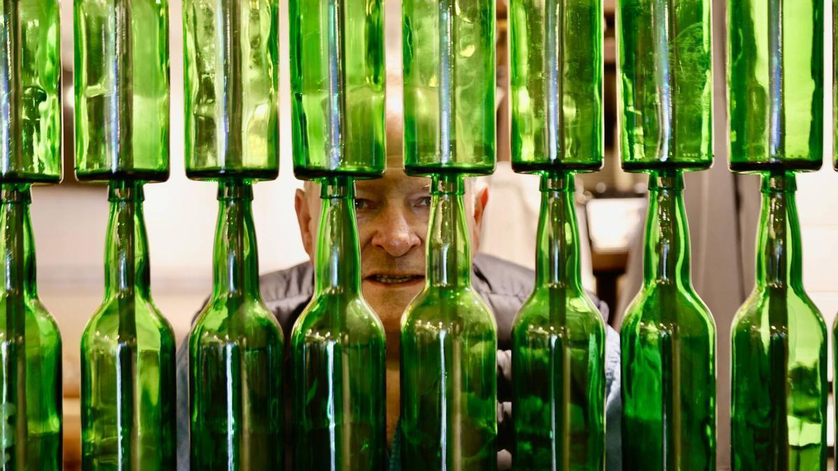 Samuel Trabanco se asoma entre varias botella de sidra.