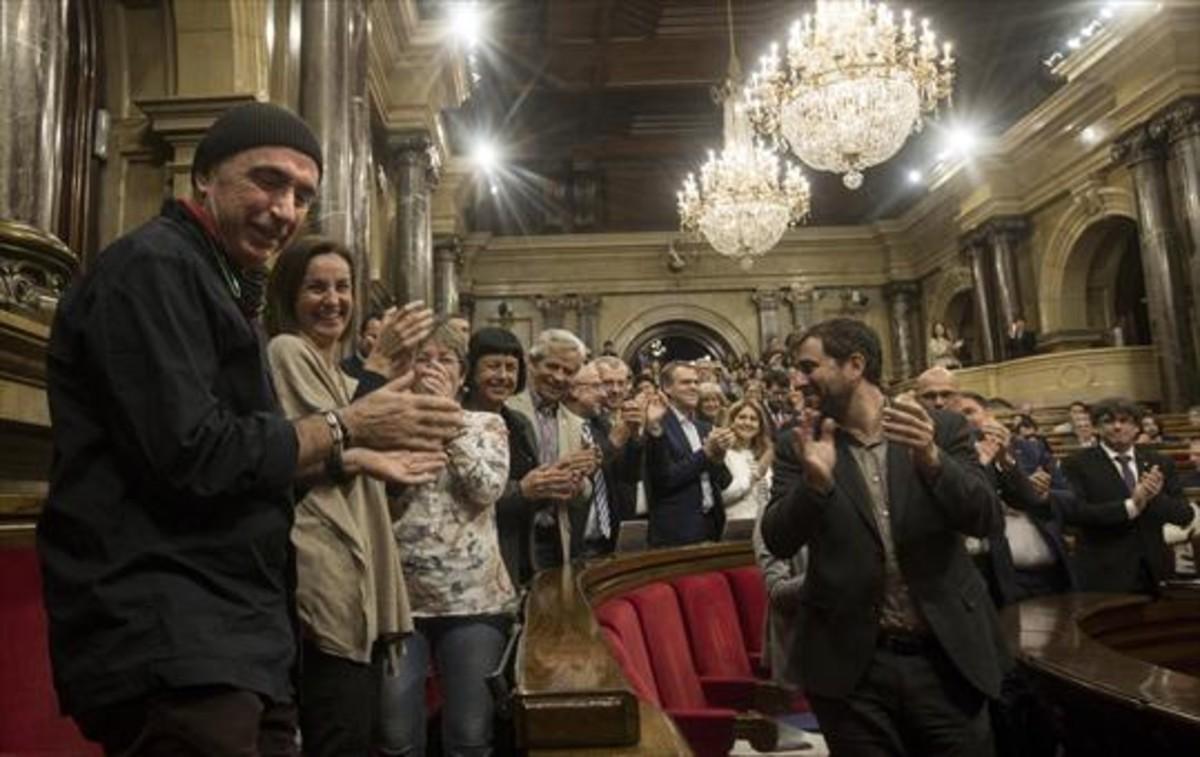 Lluís Llach recibe el aplauso de los diputados de JxSí y los miembros del Govern, ayer, en el Parlament.