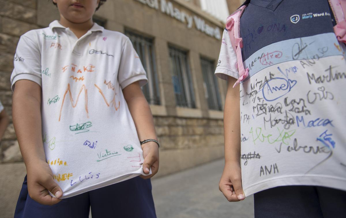 Dos alumnos del Mary Ward, a finales del curso pasado, con las firmas de sus amigos de clase en la camiseta