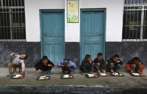 Niños chinos comen el almuerzo al aire libre en el colegio del pueblo de Tongguan. De acuerdo con el director, hay un comedor escolar, pero los estudiantes prefieren comer fuera ya hay más luz. 24 de noviembre de 2014.