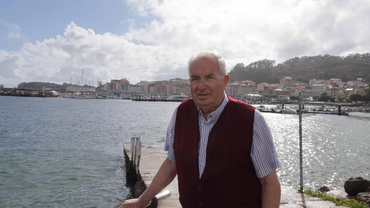 Carlos Hermelo, que será homenaxeado o luns, onte co peirao de Cangas ao fondo.
