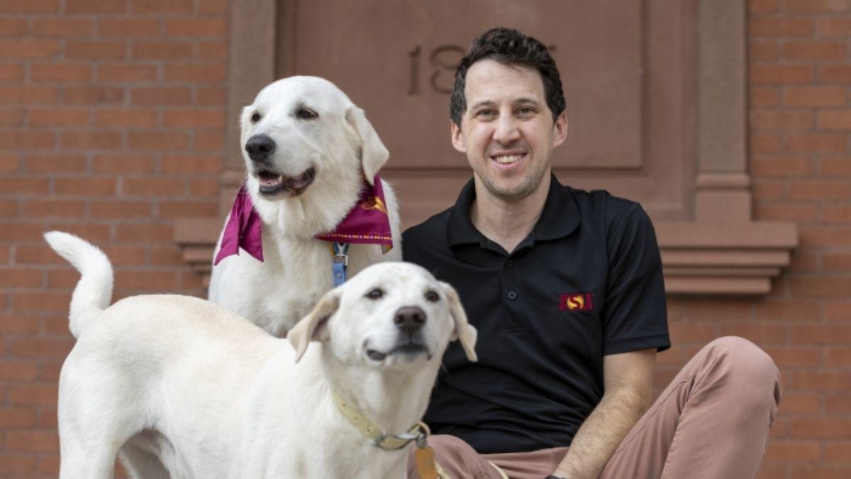 El investigador de la Universidad Estatal de Arizona, Noah Snyder-Mackler, lleva mucho tiempo interesado en comprender mejor por qué envejecen los animales y en aplicar ese conocimiento al envejecimiento humano. Aquí, posa con sus dos perros, Homer, de 7 años (abajo), y Juno, de 4 años (arriba).