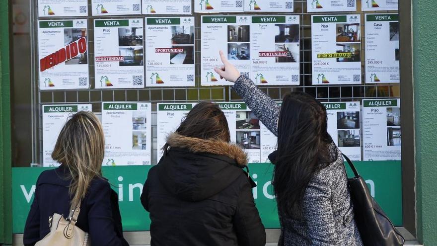 Varias mujeres comparando precios de viviendas en Vigo. // J. Lores