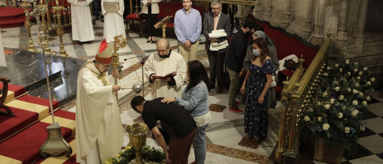 El arzobispo de Oviedo bautiza a uno de los asistentes a la celebración de los sacramentos. | F. Rodríguez