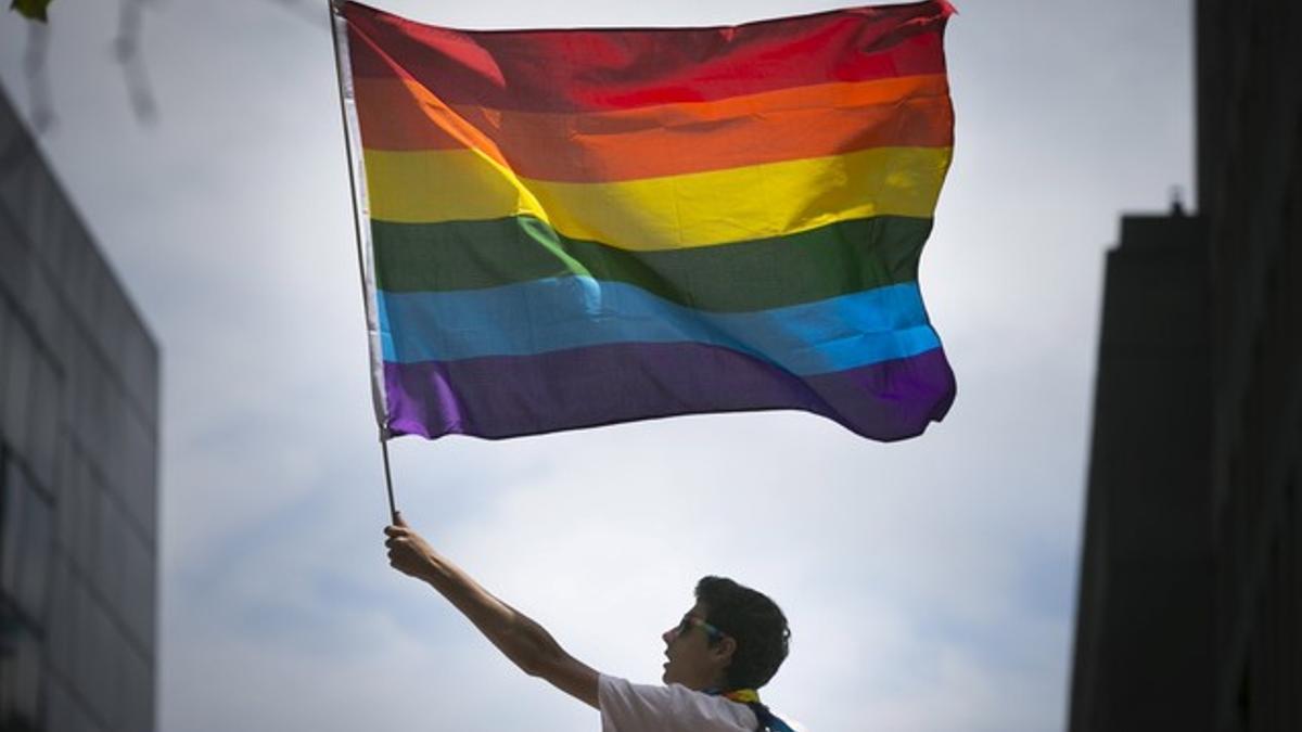 Un hombre sostiene la bandera gay del arcoiris en una marcha en San Francisco, Estados Unidos.