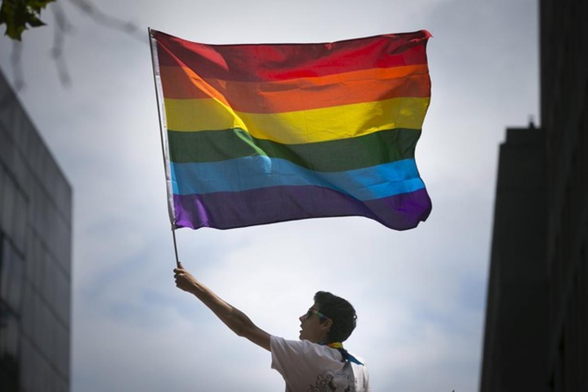 Un hombre sostiene la bandera gay del arcoiris en una marcha en San Francisco, Estados Unidos