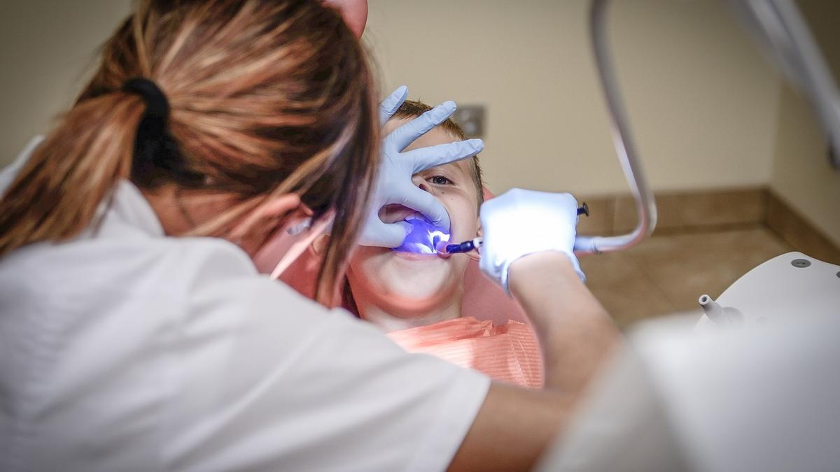 Una dentista durante un tratamiento a un niño