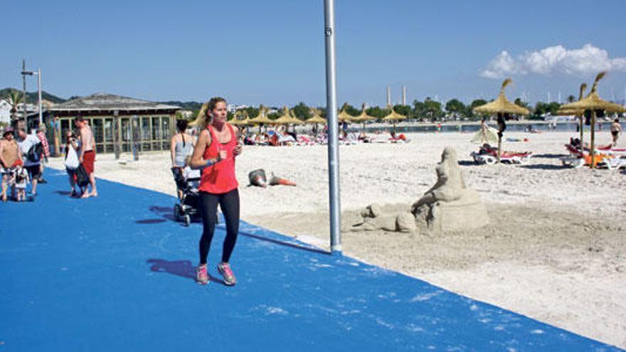 Una mujer corre por el asfalto azul colocado sobre el paseo de la playa.