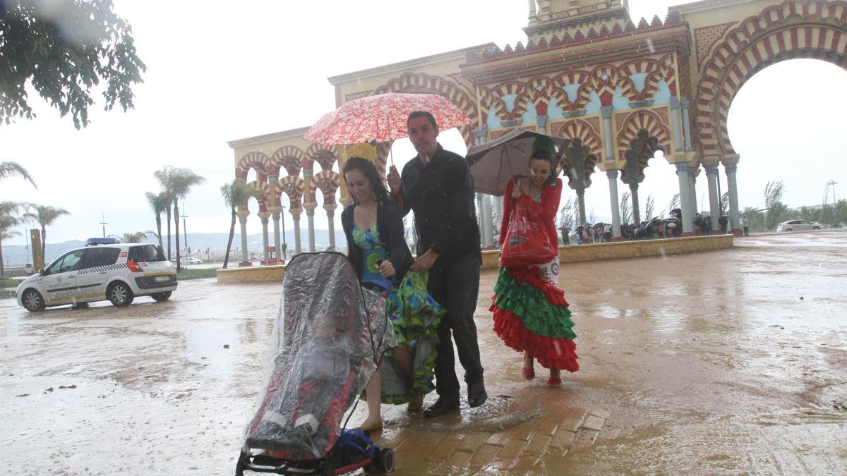 Una familia abandona el recinto ferial de El Arenal bajo la lluvia, en una imagen de archivo.