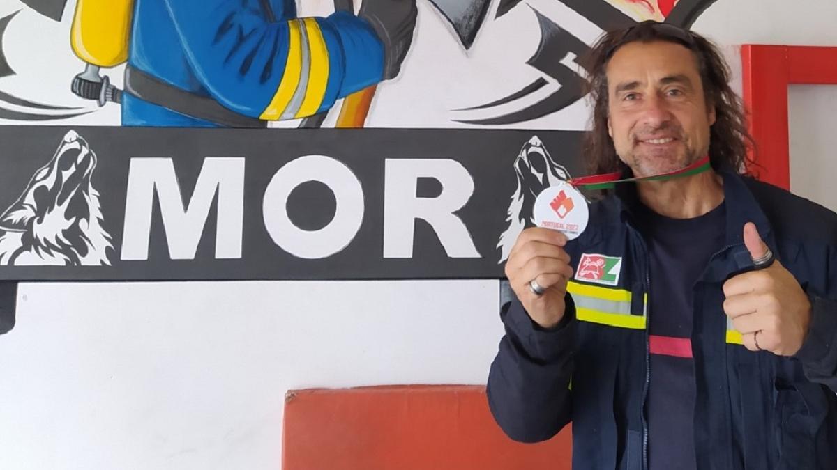 El bombero en Zamora muestra su medalla de plata en los juegos.