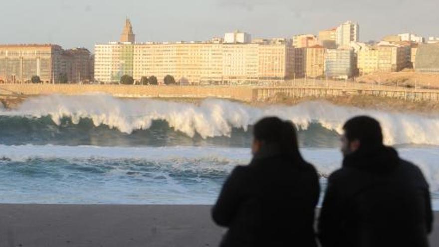 Dos personas observan el oleaje en A Coruña.