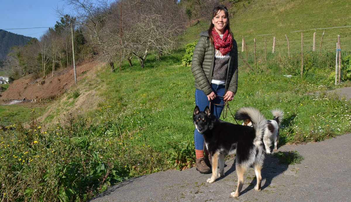 Mar Buey con dos de sus tres perros, en San Martín de Luiña.