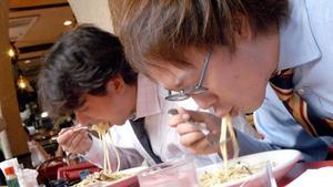 Dos hombres comen en un restaurante.