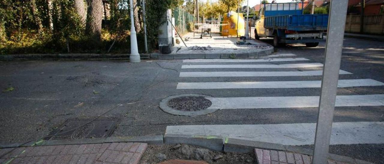 Los restos del árbol talado y, al fondo, las obras de eliminación de barreras.