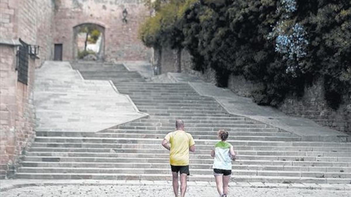 Dos corredores ascienden por las tranquilas escaleras del monasterio de Pedralbes.