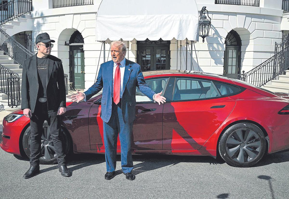 Elon Musk i Donald Trump davant d'un cotxe de la marca Tesla.