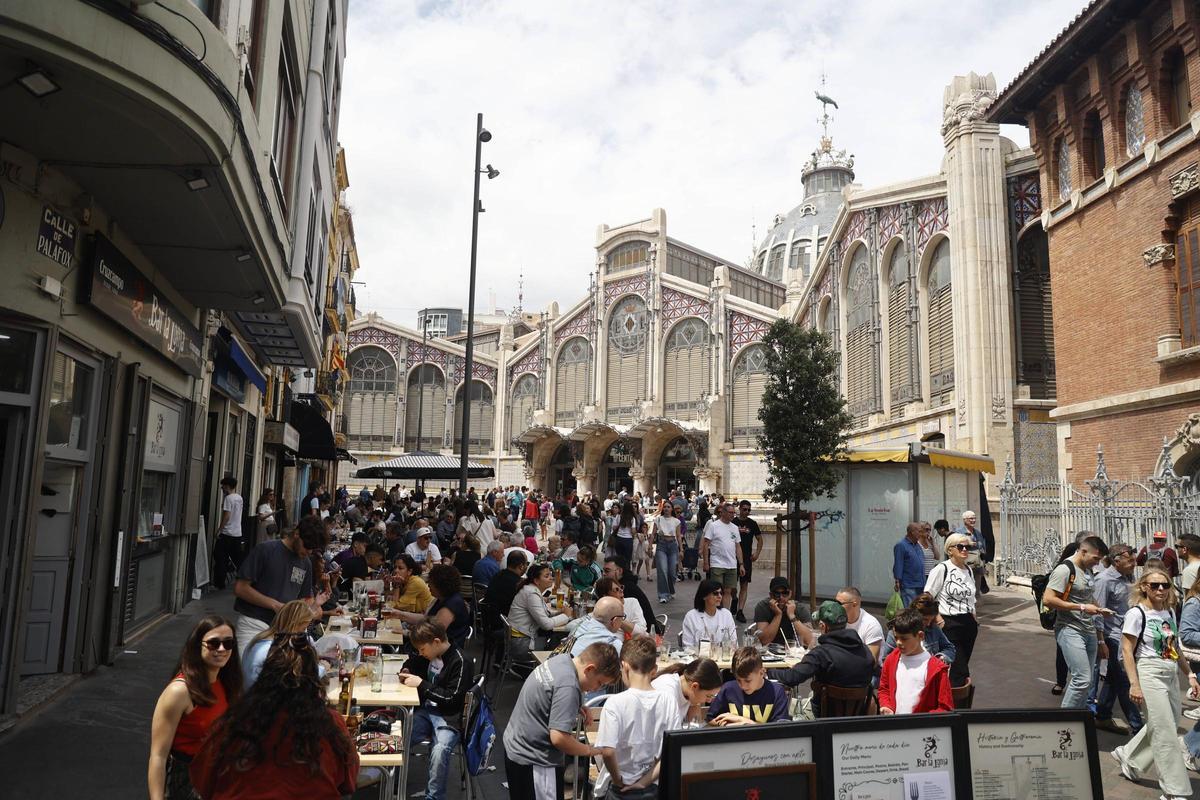 Terraza de un bar llena de turistas junto al Mercado Central de València.