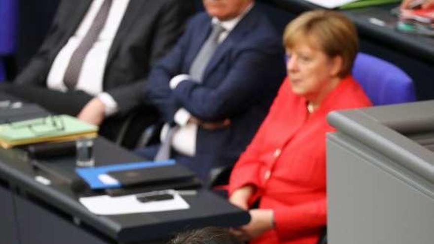 Nahles interviene en el Bundestag, con Merkel y Seehofer al fondo. // Reuters
