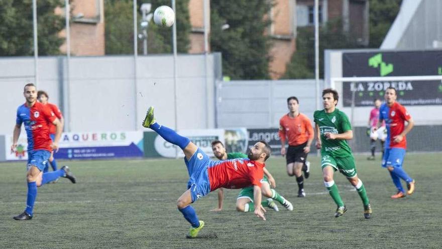 El azulgrana Omar despeja un balón durante el partido disputado por Langreo y Covadonga en Ganzábal en la primera vuelta.