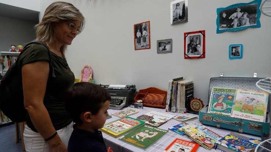 Una madre y su hijo observan los libros seleccionados.