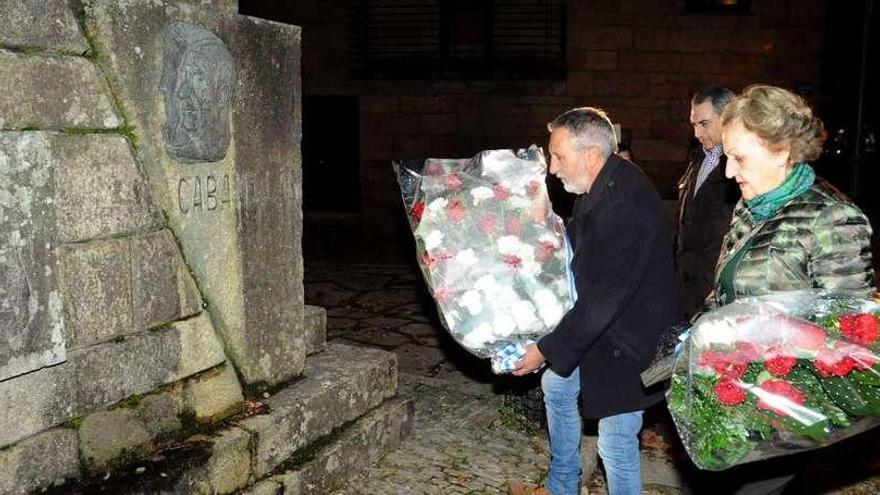 Aurora Vidal Cabanillas y Víctor Caamaño depositan unas flores ante el monumento al poeta, ante la mirada de Luis Aragunde. // Iñaki Abella