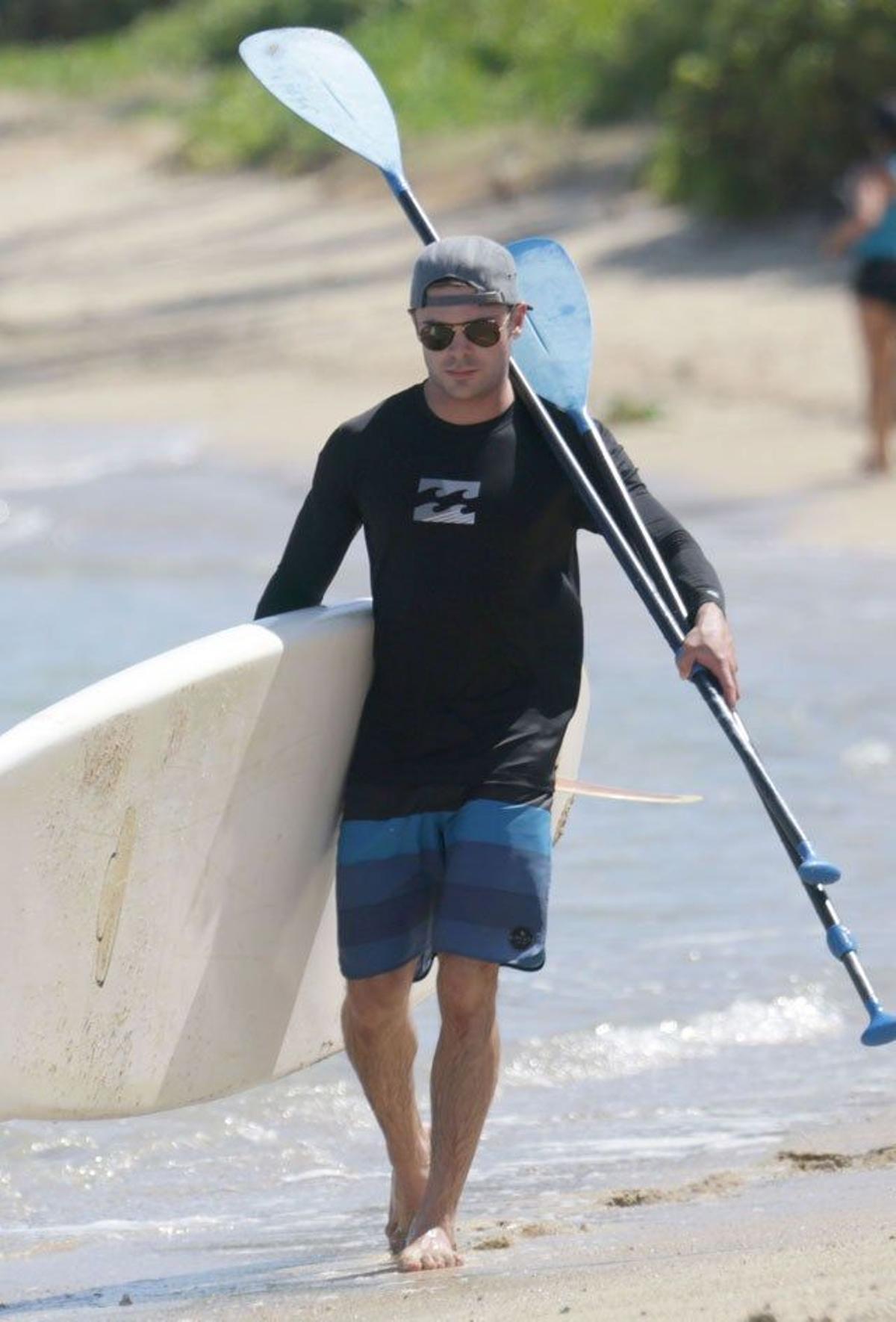 Zac Efron tras practicar paddle surf camina por la orilla