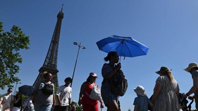 Paraigua per protegir-se del sol a París, ahir. | BENJAMIN GIRETTE / BLOOMBERG