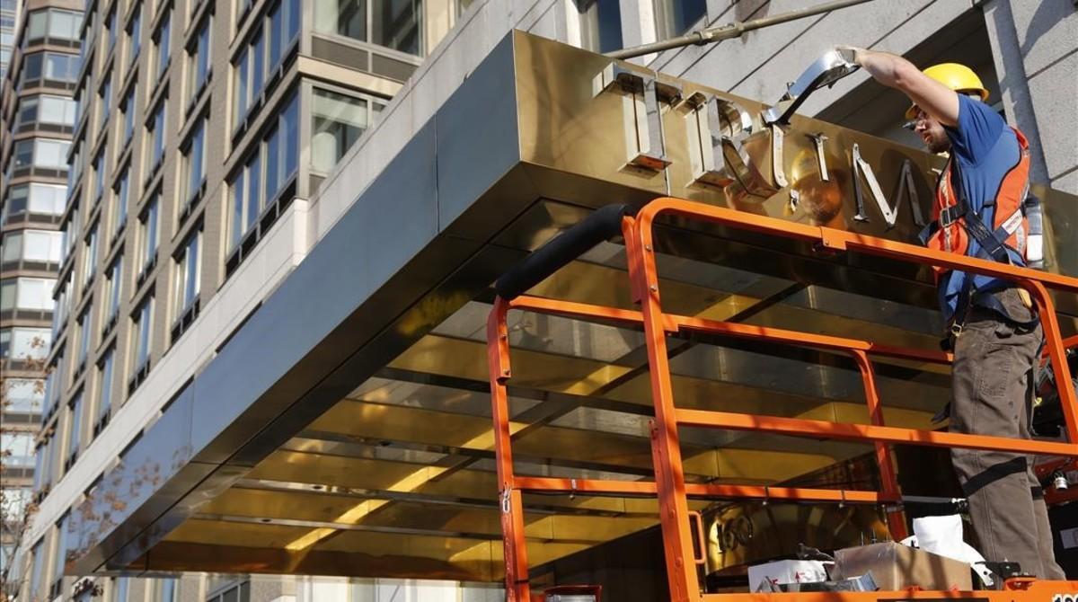 mbenach36310711 a man removes letters from the awning of a building formerly161117120107