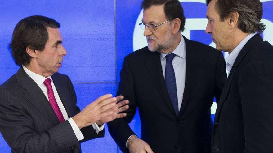 Aznar, hablando con Rajoy y Hernando. // Efe