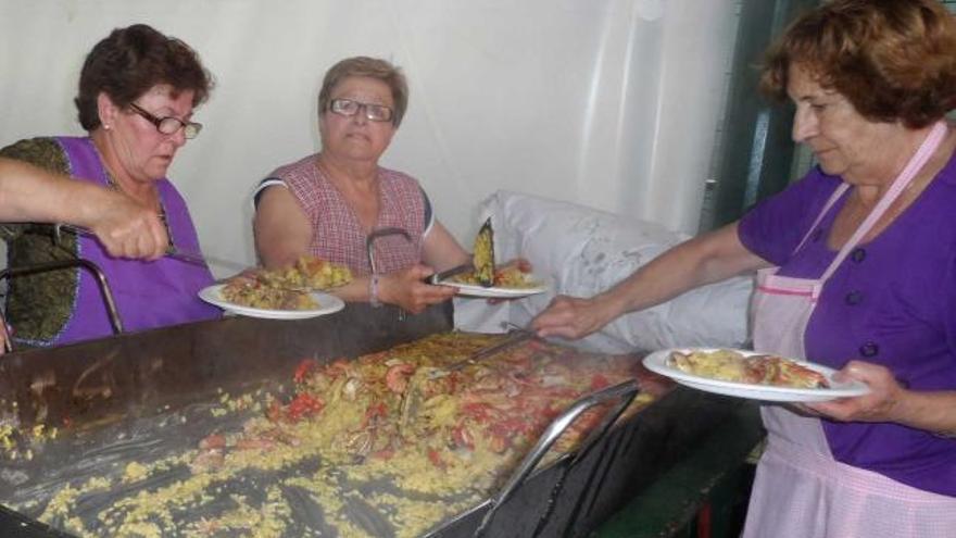 Margarita Cantera, Mary Carmen González y Soco Rodríguez sirven el arroz.