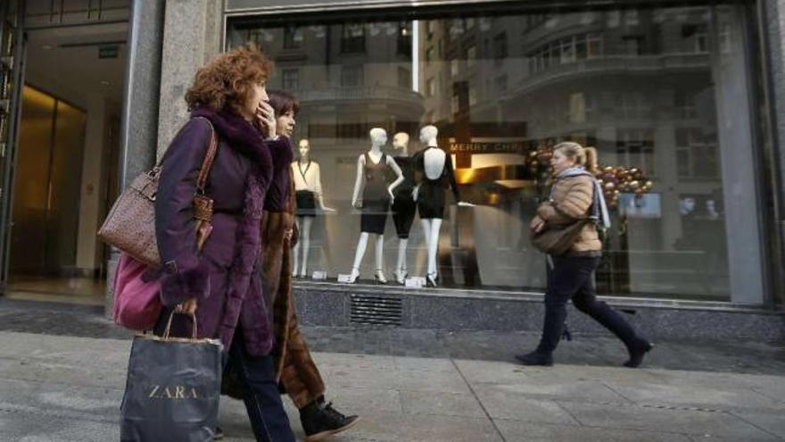 Tres mujeres pasan por delante de una tienda Zara.  // Andrea Comas