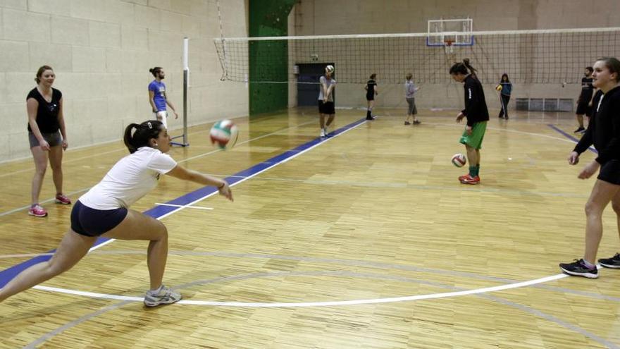 Universitarios, jugando al voleibol en el campus. // J. Lores