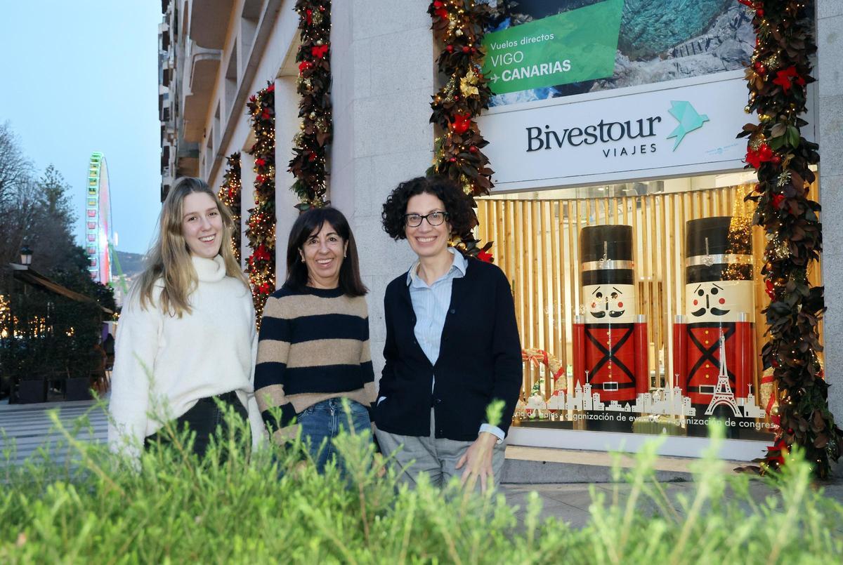 Trabajadoras de la agencia de viajes Bivestour con los escaparates adornados por fuera con motivos navideños.