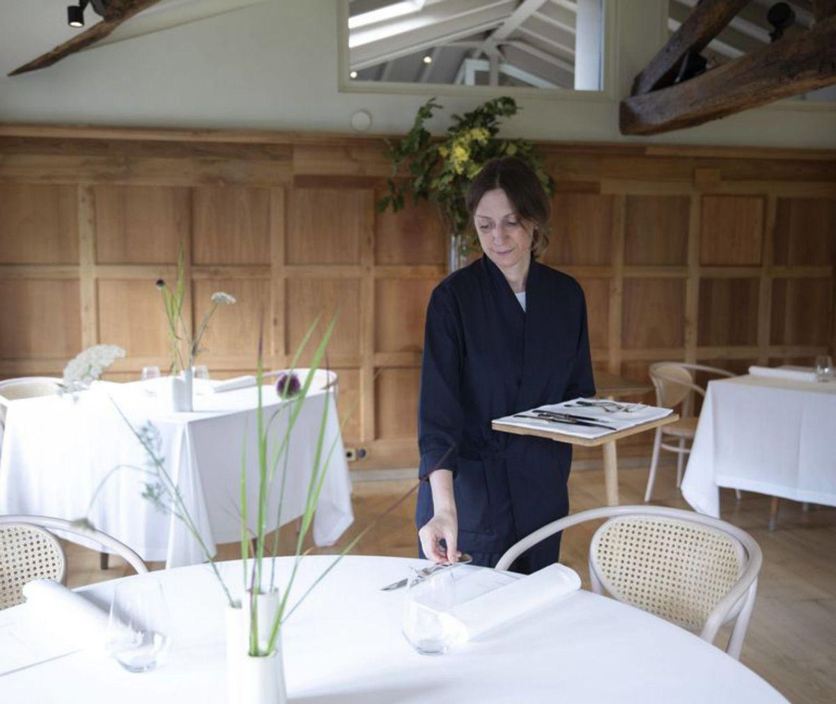Desde arriba, Chus Sánchez Manzano y Luis Rodríguez revisan un plato en la cocina; Joan Manclús sirve una copa, y Sandra Manzano pone una mesa en Casa Marcial. | fernando rodríguez