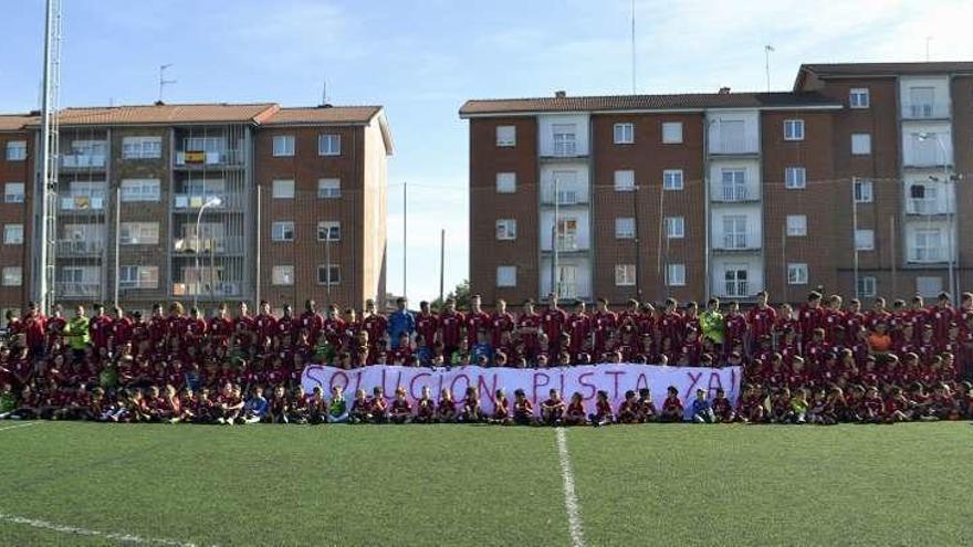 Los jugadores del Montevil con la pancarta que piden el arreglo de su pista.