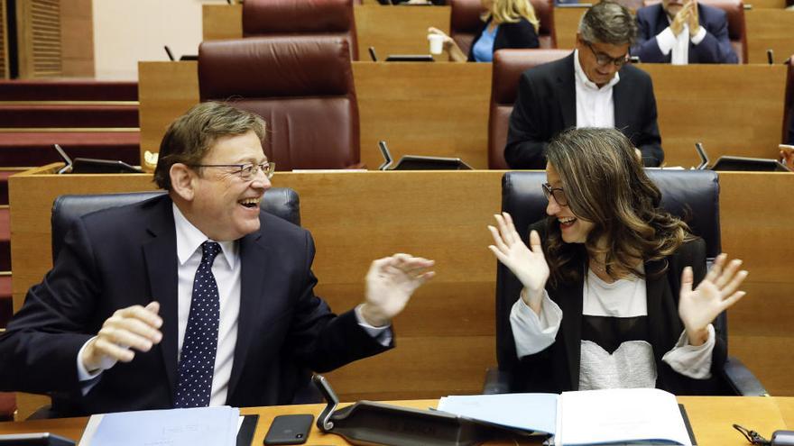 El president de la Generalitat, Ximo Puig, y la vicepresidenta, Mónica Oltra, bromean durante la sesión de control del pleno de Les Corts