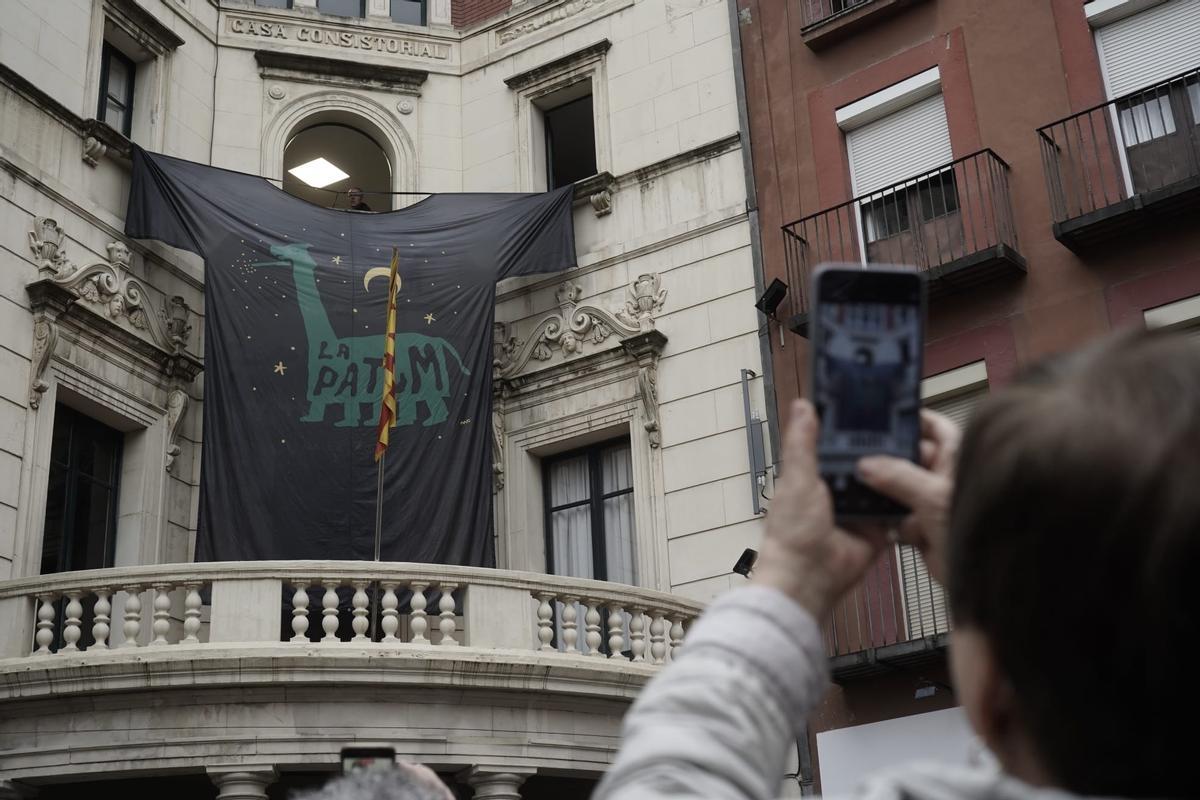 Un dels assistents a la plaça fent una foto a l'enorme samarreta que ha revelat el disseny d'enguany