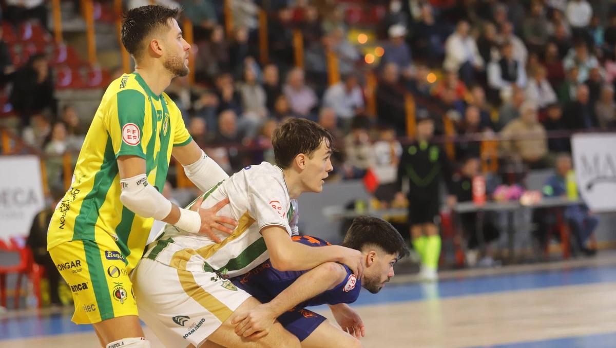 Javi Aranda, entre dos jugadores del Jaén Paraíso Interior, en el derbi de la primera vuelta.