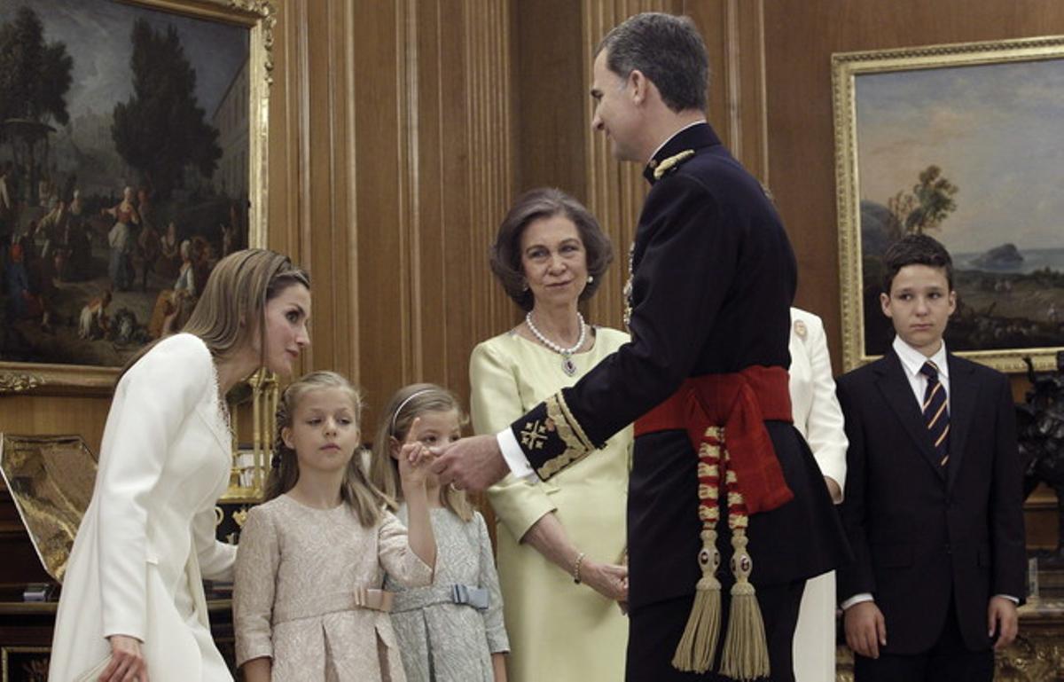 El rey Felipe VI besando a su esposa Letizia y sus hijas, la Princesa de Asturias Leonor y la infanta Sofía, la Reina Sofía y la infanta Elena junto a su hijo mayor, Felipe Juan Froilán tras la colocación del fajín.