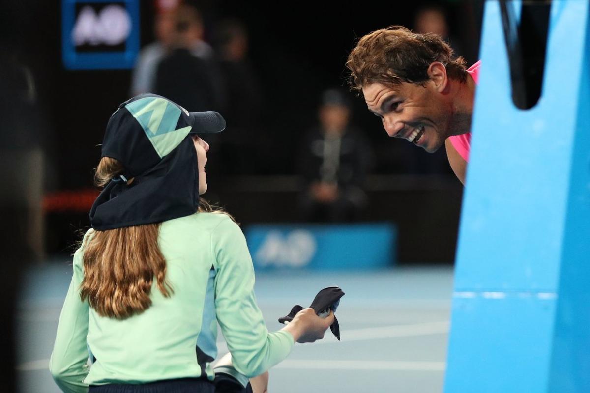 Tennis - Australian Open - Second Round - Melbourne Park, Melbourne, Australia - January 23, 2020. Spain’s Rafael Nadal passes a ball girl his head band after winning the match against Argentina’s Federico Delbonis. REUTERS/Hannah McKay Tennis - Australian Open - Second Round - Melbourne Park, Melbourne, Australia - January 23, 2020. Spain’s Rafael Nadal passes a ball girl his head band after winning the match against Argentina’s Federico Delbonis. REUTERS/Hannah McKay